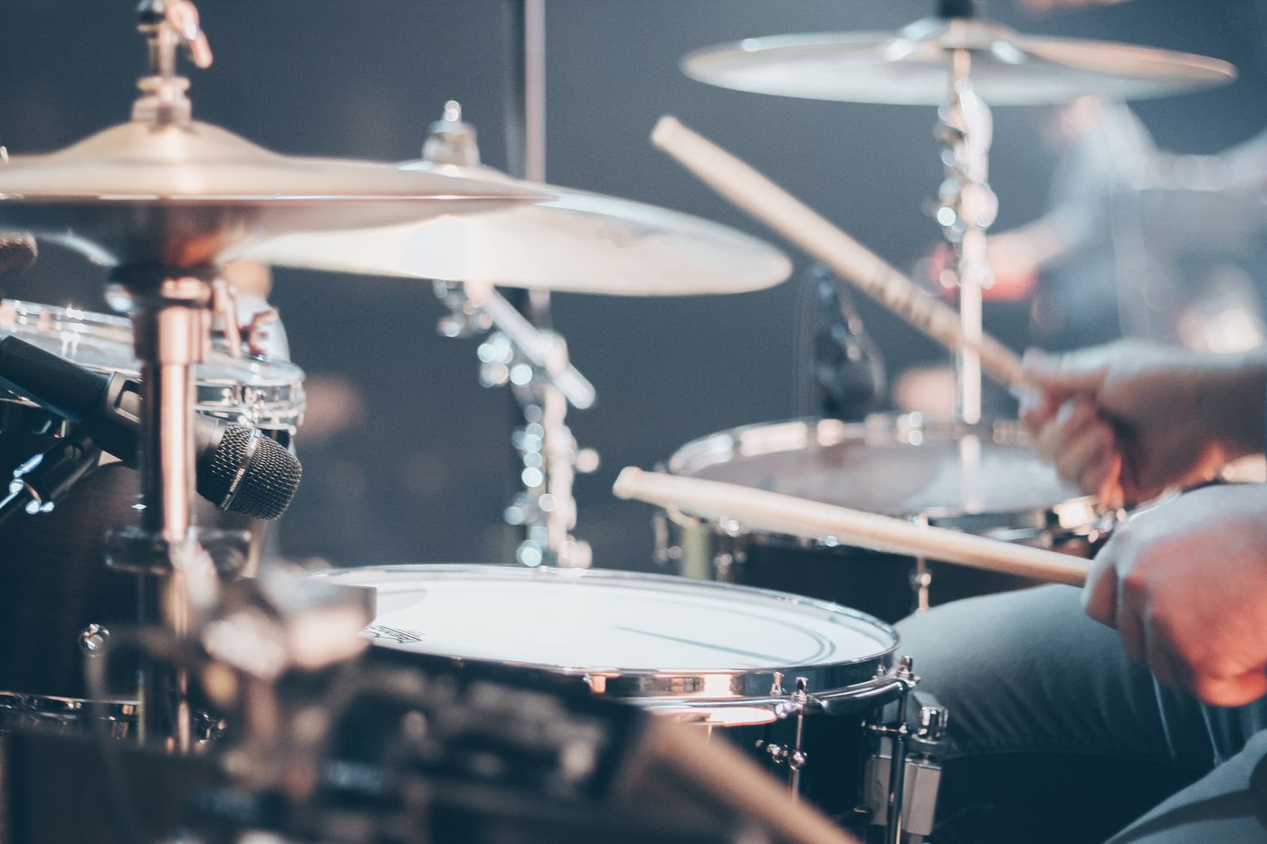 Schlagzeuger spielt an einem Set mit Becken und Snare, Sticks in Bewegung